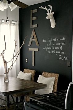 a dining room table with chairs and a deer head on the wall