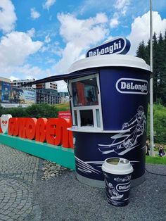 a blue and white kiosk sitting on the side of a road