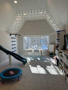 a play room with a slide and bookshelf