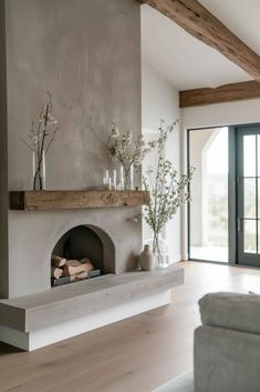 a living room filled with furniture and a fire place in front of a fireplace covered in logs