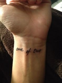 a person with a tattoo on their wrist that says one of them