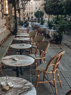 tables and chairs are lined up on the sidewalk