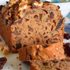 a loaf of bread with nuts and raisins sitting on a plate next to another loaf