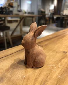 a small wooden rabbit sitting on top of a table