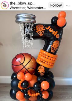 an inflatable number five balloon sculpture with basketballs and balloons attached to it