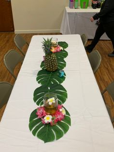 the table is set up with pineapples and flowers