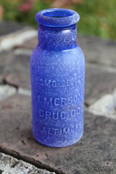 a blue glass bottle sitting on the ground