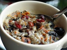 a bowl of oatmeal with raisins and dried cherries in it