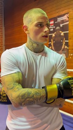 a man with tattoos on his arm holding a boxing glove