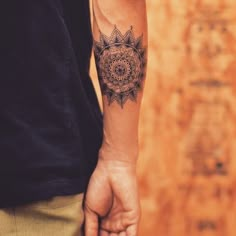 a man with a tattoo on his arm holding the hand of another person's hand