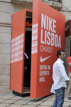 two men are talking in front of a nike display