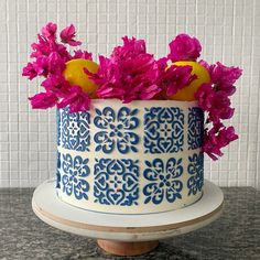 there is a blue and white cake with flowers on top that has two lemons in it