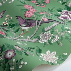 a green wallpaper with birds and flowers on it