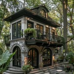 a house in the woods with lots of trees and plants on it's roof