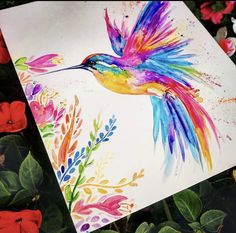 a painting of a colorful hummingbird on white paper surrounded by red and pink flowers