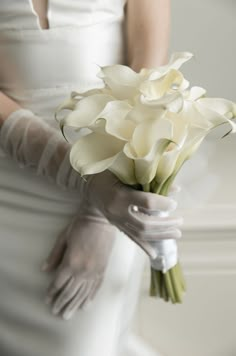 a woman in white dress holding a bouquet of flowers