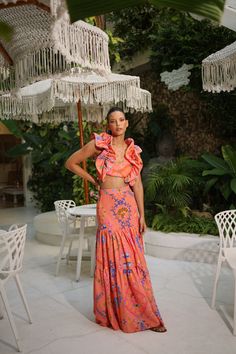 PRE-SALE DESCRIPTION: This exquisite two-piece skirt set is a statement of bold elegance, featuring a vibrant coral color adorned with intricate paisley and floral patterns in shades of blue, pink, and green. The cropped top showcases voluminous ruffled sleeves and a fitted bodice, offering a dramatic yet feminine touch. Paired with a high-waisted, tiered maxi skirt that flows effortlessly with every movement, this set is perfect for a summer getaway or a stylish day out. The lightweight fabric Orange Two Piece, Tiered Maxi Skirt, Summer Getaway, Ruffled Sleeves, Coral Color, Cropped Top, Floral Patterns, Fitted Bodice, Swimwear Tops