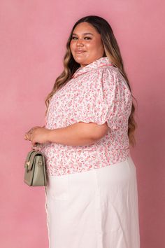 The Sophia Blouse in Coral Floral features a white base with a vibrant multicolored floral print, making it a perfect addition to your spring wardrobe. The round neckline is accented with a coral eyelet collar, adding a touch of color. The short puff sleeves feature an elastic closure and ruffle hem, while the functional buttons and pleating down the bodice create a flattering silhouette. This blouse also has a button-up style, making it nursing friendly for all the Ivy mamas out there. City Woman, Nursing Friendly, Spring Wardrobe, Coral Color, Up Styles, Ruffle Hem, Base Colour, Puff Sleeves, Round Neckline