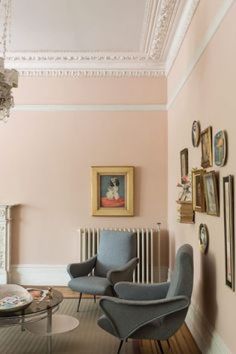 a living room filled with furniture and pictures on the wall next to a radiator