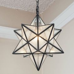 a light fixture hanging from the ceiling in a room with a star design on it