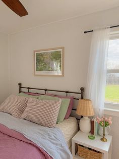 a bedroom with a bed, nightstand and window