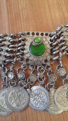 "80's silver tone Afghan Kuchi faux coin choker. There are green glass beads in the centre piece and at the ends, chain clasp at the back. Length in total 23\", at shortest 17 1/2\", width 1 1/2\"" Vintage Metal Necklace With Coin Pendant, Vintage Silver Coin Necklace For Festivals, Vintage Silver Chain Necklace For Festivals, Metal Coin Necklace For Festivals, Vintage Metal Coin Necklace With Round Pendant, Vintage Green Choker Necklace, Green Coin Pendant Medallion Jewelry, Vintage Nickel Free Choker Necklace, Nickel-free Vintage Choker Necklace