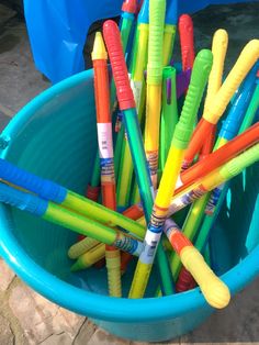 a blue bucket filled with lots of colorful crayons in it's side