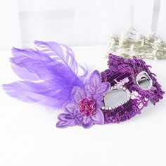 Purple Sequin and Feather disguise. Whether it is a Masquerade or Halloween, this Purple Sequin and Feather disguise is sure to enchant the evening.    The detailing of this disguise complements a costume or plain dress for a simple-yet-charming disguise. The attached feathered accent, along with rose offer a dramatic look.    One size fits most Elegant Halloween Theater Costumes, Purple Fantasy Costume For Halloween, Elegant Halloween Costume For Costume Party, Fantasy Costume Mask For Costume Party, Fantasy Costumes For Carnival Masquerade, Fantasy Costume For Masquerade Carnival, Fantasy Costume For Costume Party In Purple, Fantasy Purple Costume For Costume Party, Carnival Eye Mask For Costume Party