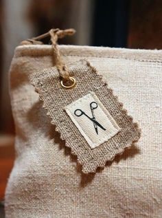 a close up of a bag with a pair of scissors on the tag hanging from it