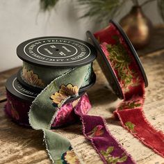 two spools of ribbon sitting next to each other on top of a wooden table