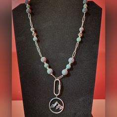 Handcrafted. 22" Long. Made With 8mm Fancy Jasper Beads, 10mm Iris Rainbow Lava Beads, 9mm Fire Polished Baroque Beads, Antique Silver Spacer Beads, 27.5x25mm Stainless Steel Mountain Pendant, 29x12mm Carabiner Clasp, Chain And Toggle Clasp. Mountain Pendant, Carabiner Necklace, Fancy Jasper, Lava Beads, Lava Bead, Jasper Beads, Toggle Clasp, Artistic Jewelry, Spacer Beads