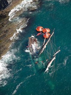 an aerial view of a boat in the ocean with life vests attached to it