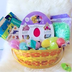 a basket filled with lots of different types of easter eggs and candy in front of a white furnishing