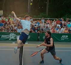 two men playing tennis in front of an audience