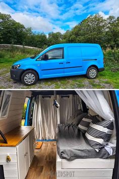 a blue van parked in the grass next to a bed and desk with pillows on it