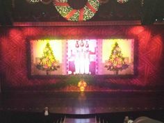 the stage is decorated for christmas with lights and decorations on it's walls, as well as wreaths