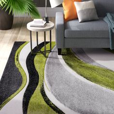 a living room with a gray couch and green rug