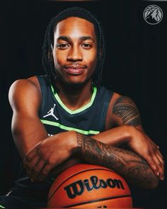 a man with dreadlocks holding a basketball