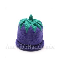 a knitted purple hat with green leaves on it