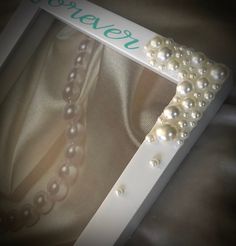 a white frame with pearls and a name on it