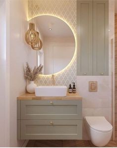 a bathroom with a round mirror above the sink and a white toilet next to it