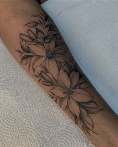 a woman's arm with black and white flowers on the left side of her body