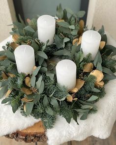 a wreath with white candles and greenery