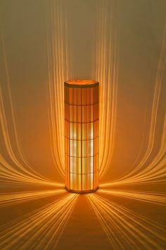 a tall light fixture sitting on top of a floor next to a curtained wall