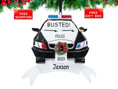 a police car ornament hanging from a christmas tree