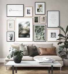 a living room filled with lots of pictures on the wall next to a white couch