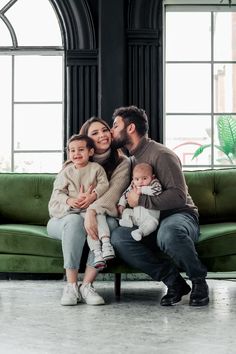 a man, woman and two children sitting on a couch