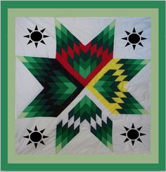 a green and white quilt with geometric designs on it