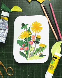 some crafting supplies are laying out on a green mat with flowers and leaves painted on it