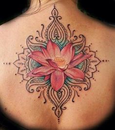 the back of a woman's neck with a lotus tattoo on it